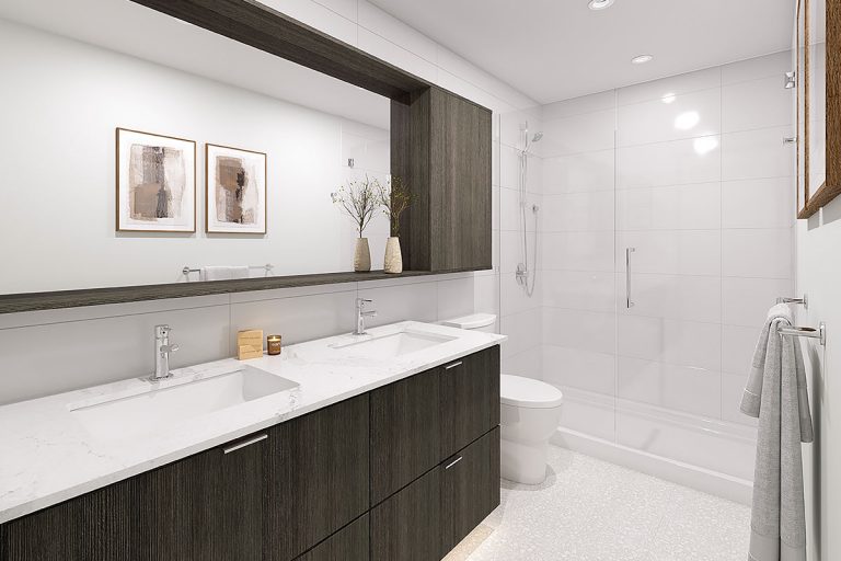 A bathroom from NEST, showing a shower, toilet, sinks, and a large mirror.